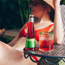 A bottle of Phony Mezcal Negroni next to a poured glass