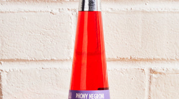 St. Agrestis Phony Negroni bottle against white brick wall