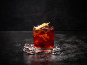 Classic Negroni cocktail with ice and orange peel garnish served in a glass on a dark surface