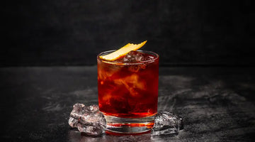 Classic Negroni cocktail with ice and orange peel garnish served in a glass on a dark surface